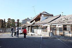 地震の影響で家の破損状況を確認しにきた人々の写真