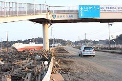 津波によって国道6号線の脇に打ち上げられた漁船と沢山の流木の写真