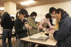 食量班総出で避難所へ届ける為におにぎりをにぎっている写真