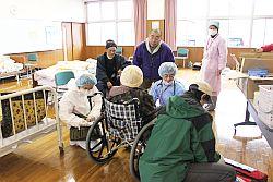 鹿島保健センターに避難された車いすの方の健康状態を確認されている方々の写真