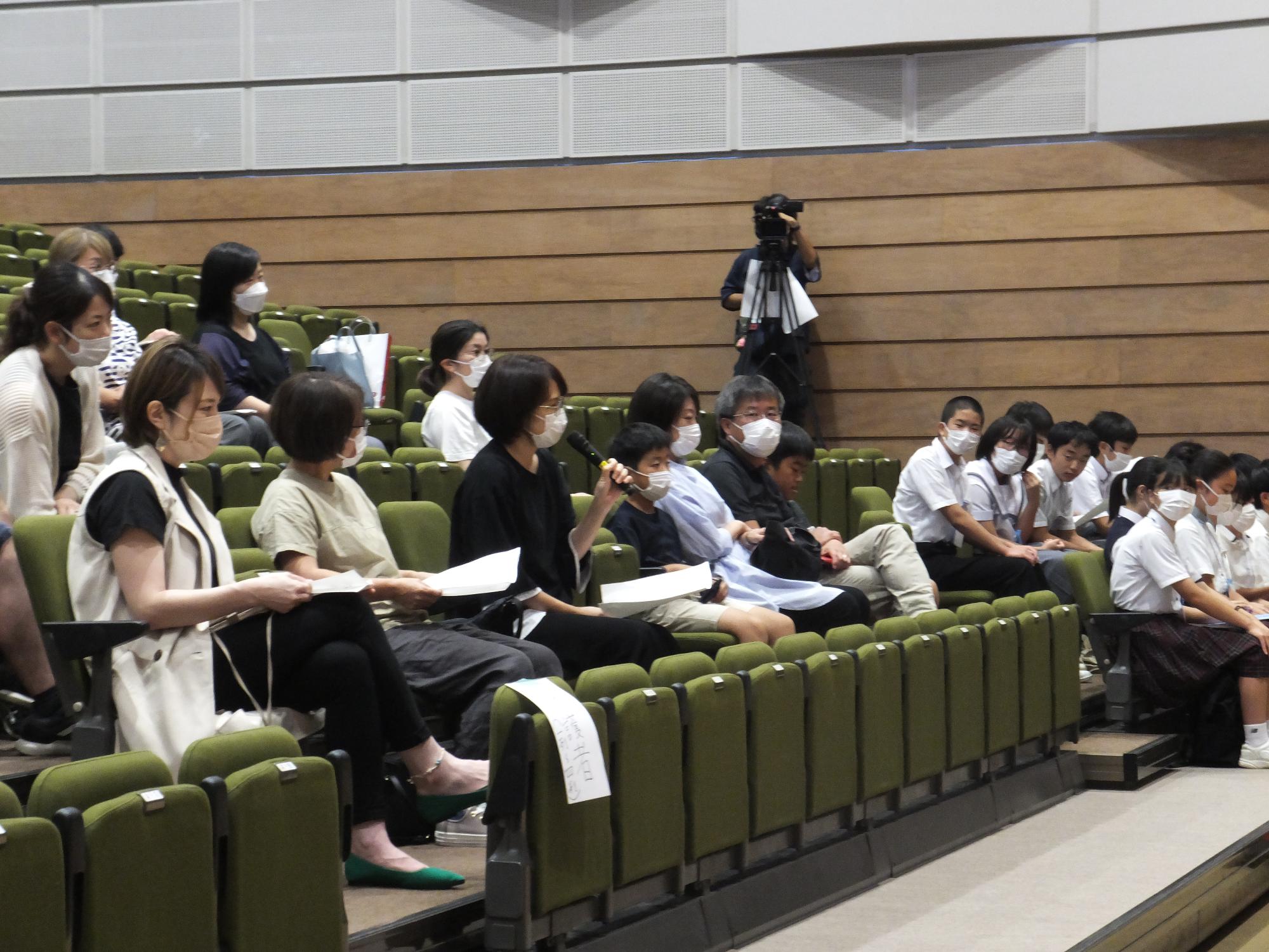 報告会を聞いている保護者らの写真