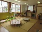 畳敷きでちゃぶ台や玩具があるサロンの部屋の写真