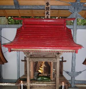 赤い屋根の牛頭天王の祠にキュウリが供えて