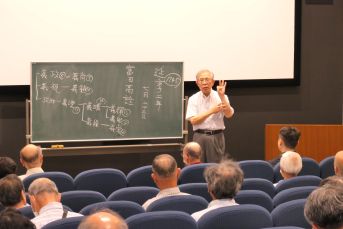 黒板を使って解説する講師それを座って聞く受講者たち