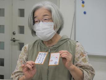 作ったカルタを手にして発表する参加者の女性