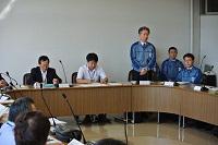 作業着の男性が起立し、話をしている特別委員会の様子の写真