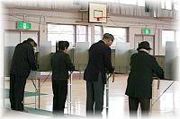 4人の人が選挙の記入をしている写真