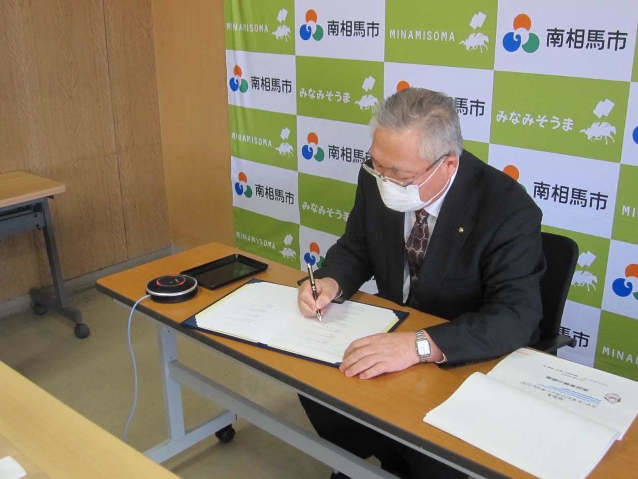 市長が協定書に署名している様子
