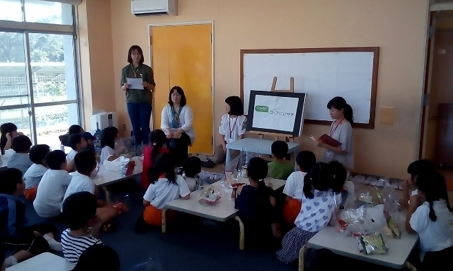 子どもたちと一緒におやつを食べてお話ししている写真