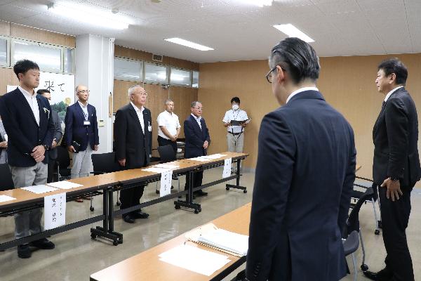 2立って向かい合う小早川代表執行役社長たちと門馬市長たちの写真