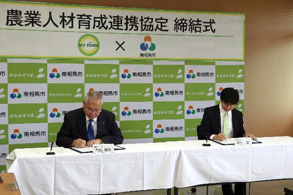 2協定書を署名する門馬市長と西辻代表取締役の写真