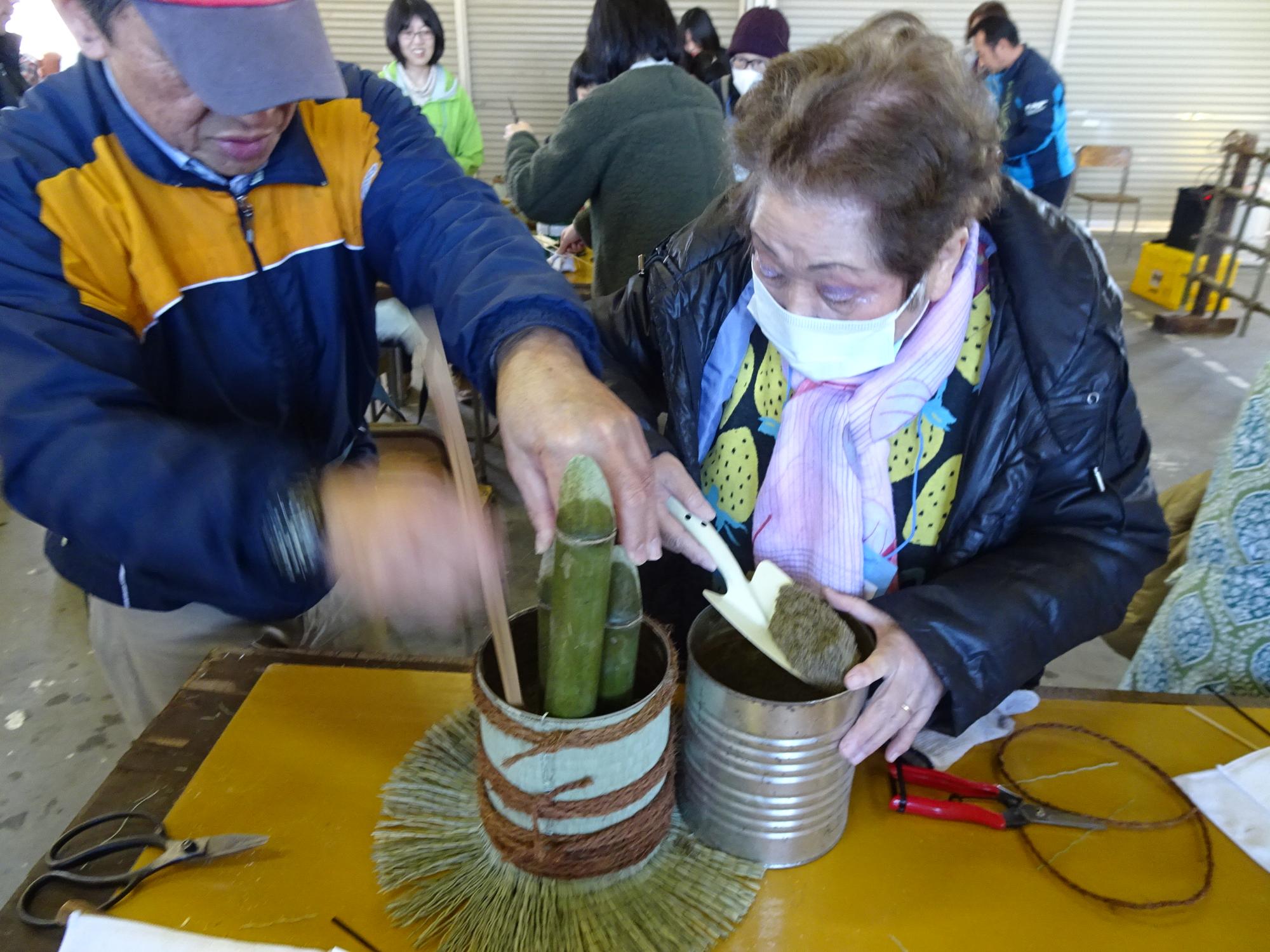 参加者が缶の中に砂を入れている様子の写真