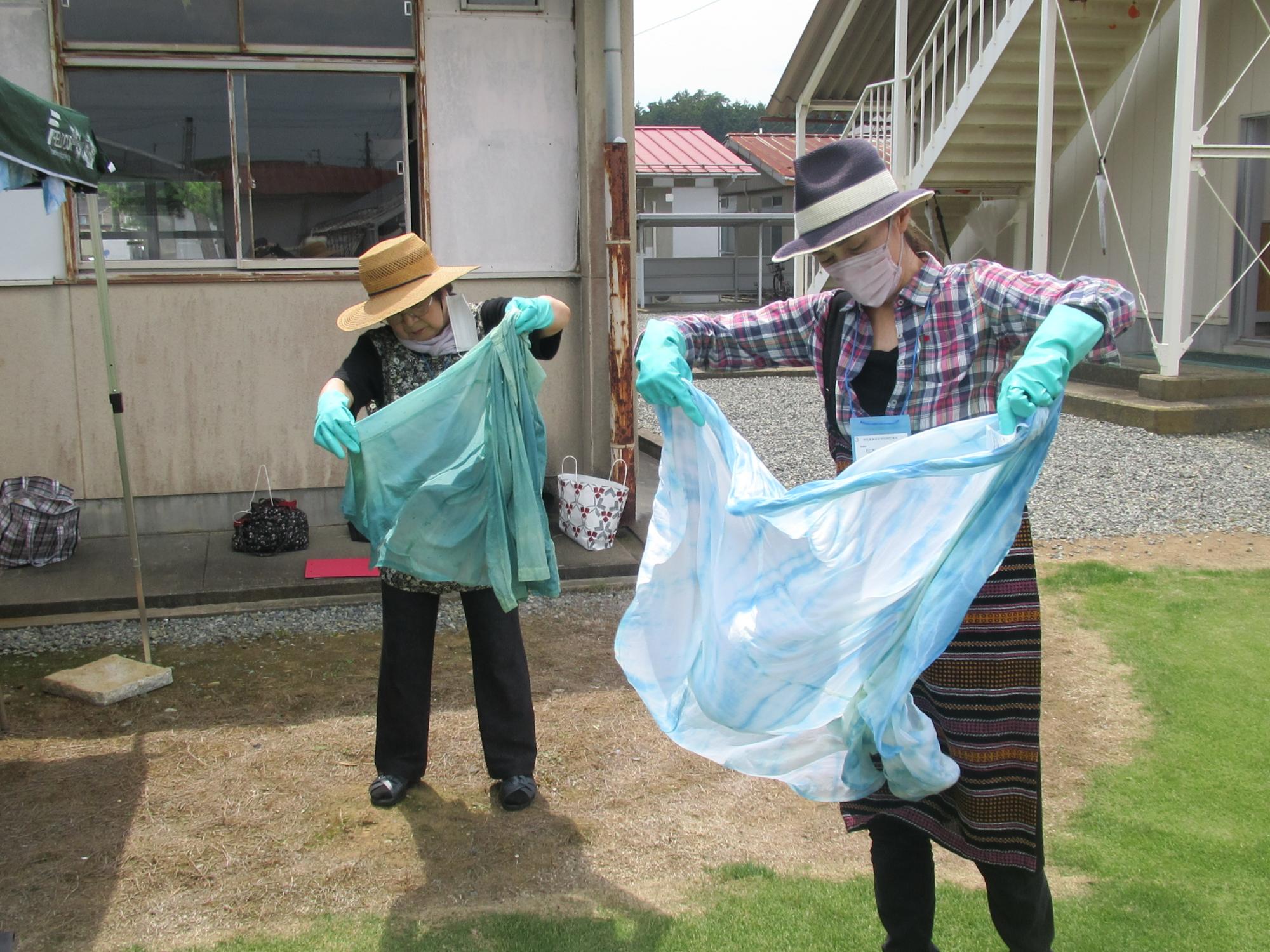 完成した藍染めを広げている参加者の写真
