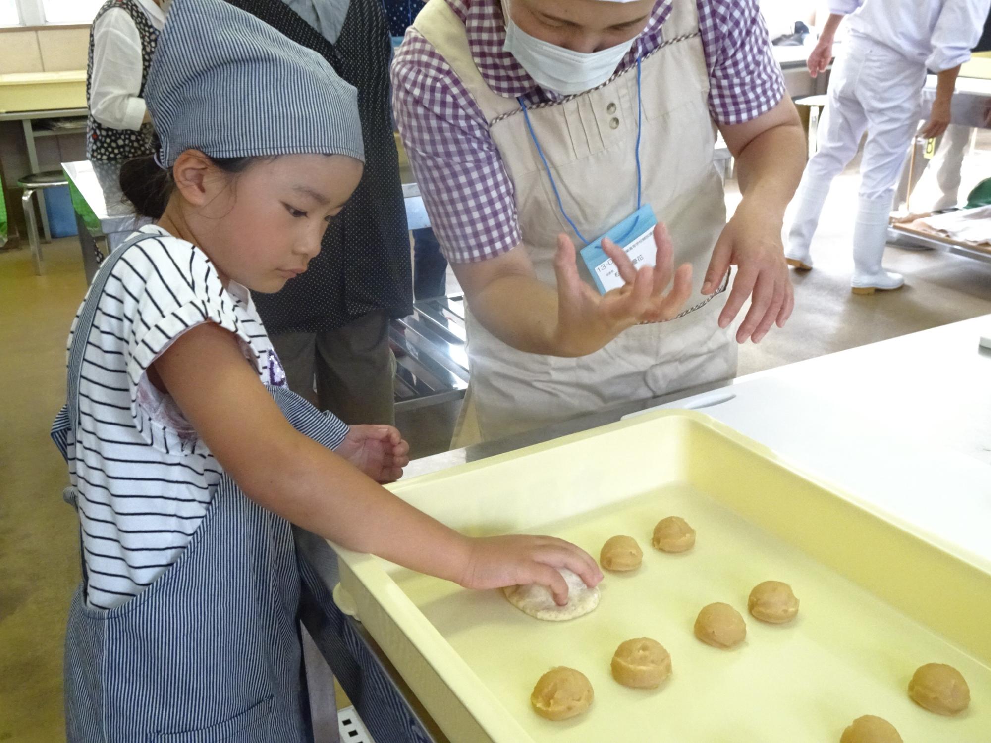 あんこを生地で包む様子の写真