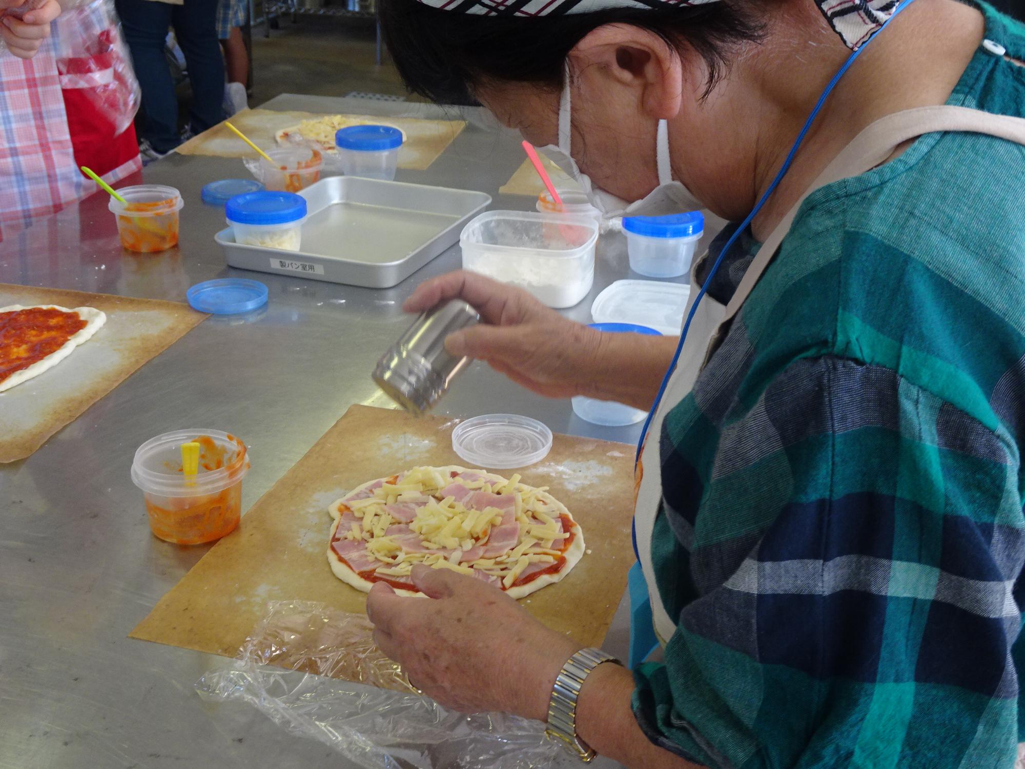 トッピングをのせてピザパンを仕上げている写真