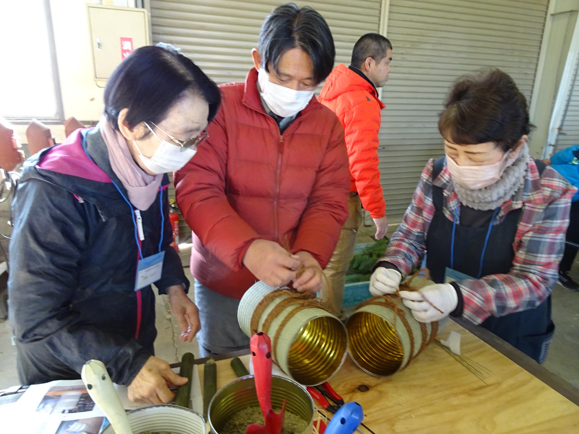 参加者が畳表の巻かれた缶に麻縄を撒いている様子の写真