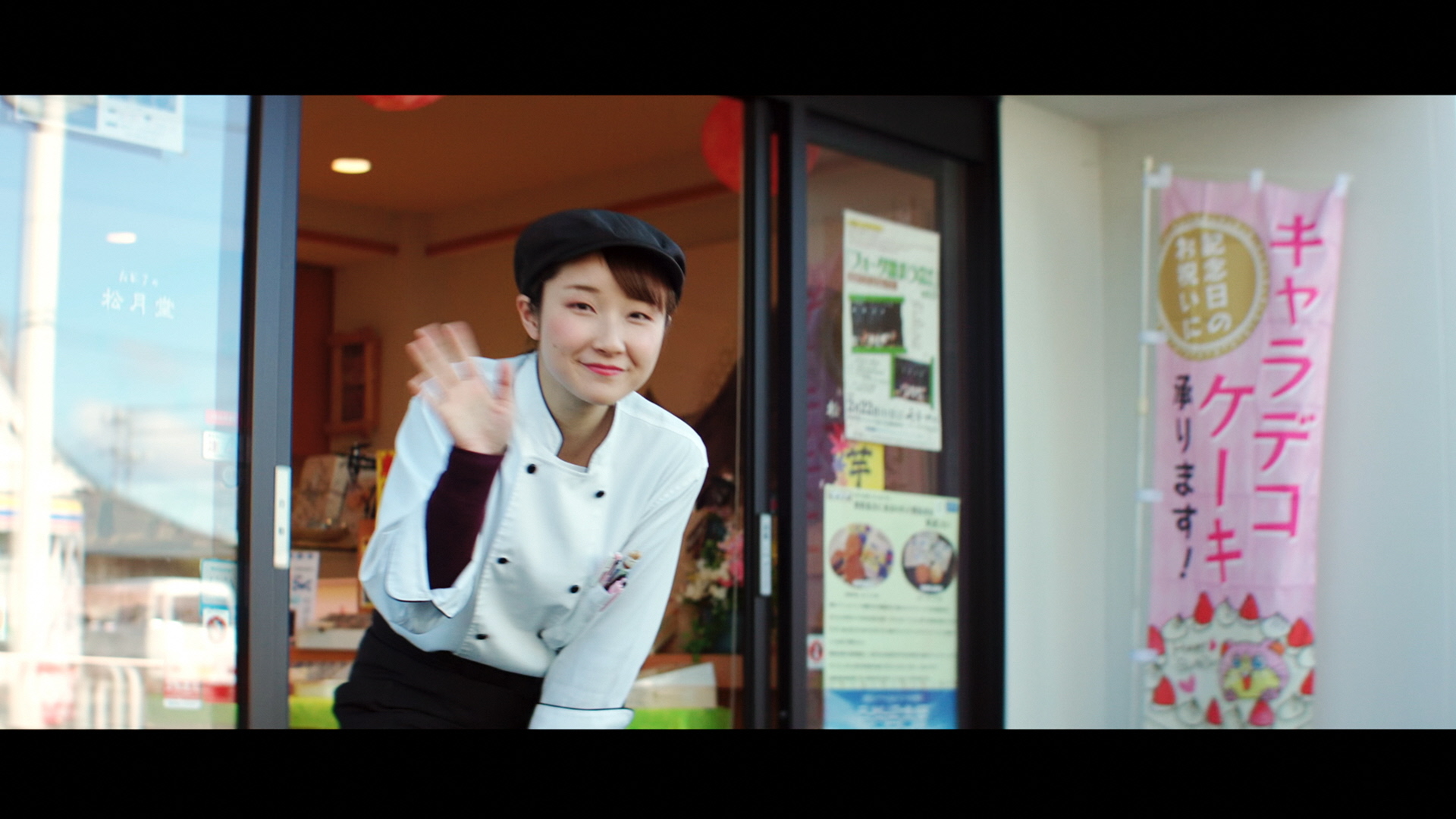 動画のサムネイル 配送ロボットに手を振る菓子店の人