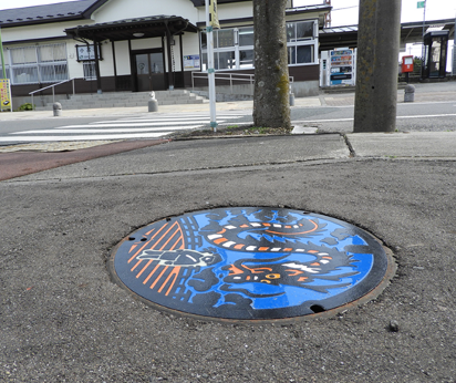 JR小高駅前にある新たに彩色を施した大蛇物語をモチーフにしたマンホールの写真