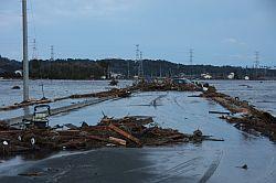 津波が全てを飲み込み、木材などの残骸で道路が寸断されている写真
