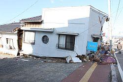 地震の影響で一軒家一階部分が全壊している写真