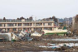 真野小学校のグランドに津波で流されてきた漁船が散乱している写真