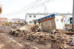 津波で流された瓦礫の山が道路上に続く原町区上渋佐の写真