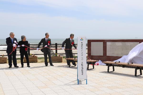 記銘碑の除幕を行う市長や遺族代表など4名の写真