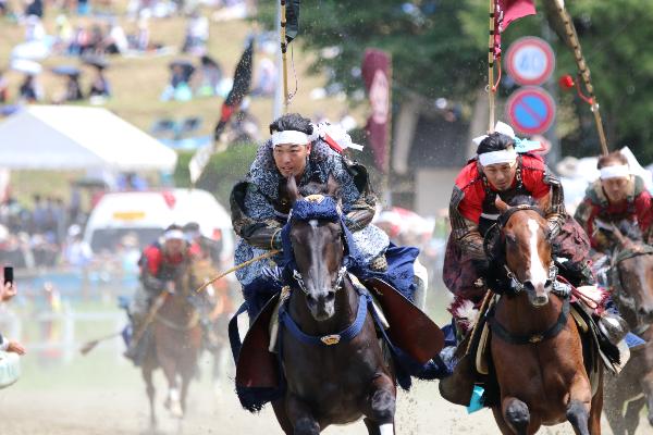 甲冑競馬に参加する二人の騎馬武者を撮影した写真