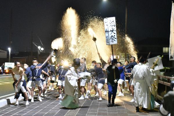 鹿島橋の上で「火伏せ」の掛け声とともに一斉に水を掛ける氏子たちの写真