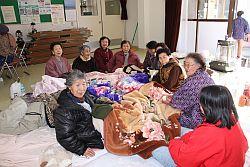 福浦小学校に避難された女性の方々が毛布を足元にかけて座っている写真