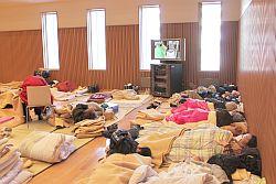 市民文化会館ゆめはっとに避難された方々が布団を敷いて寝ている写真