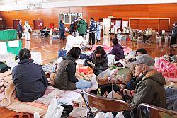鹿島中学校に避難された方々が布団を敷いて座っている写真
