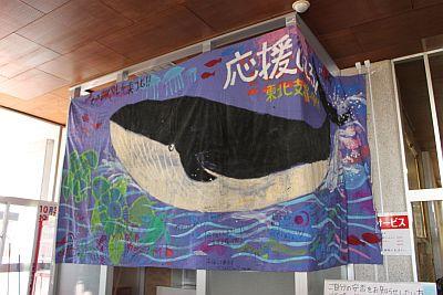 旗いっぱい大きく書かれたクジラの絵と園児からの寄書きが記載された旗の写真