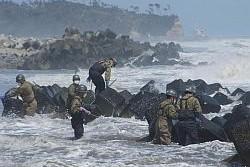 荒れる海の中行方不明者捜索をしている陸上自衛隊第一空挺団の人々の写真