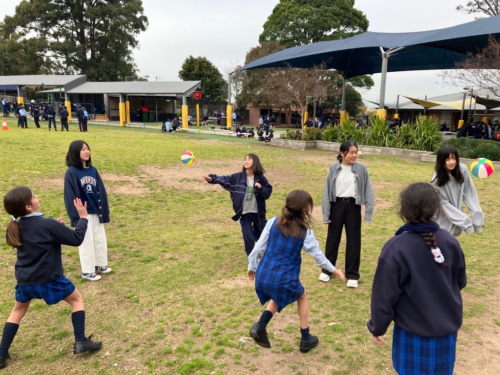 外で紙ボールを使って遊ぶ現地校の学生たちと南相馬市の学生たちの写真