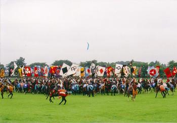 草原でたくさんのお馬武者たちがそれぞれ家のしるしの旗を持っている写真