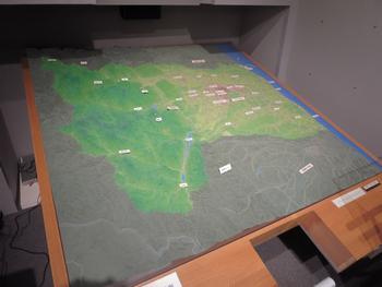 木枠に嵌められた各地名付きの地形ジオラマの写真