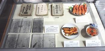 複数の文書と、三種類の料理のサンプルの展示の写真