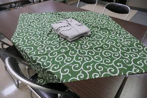緑色の唐草模様の風呂敷の上に畳んだ服を置いたところ
