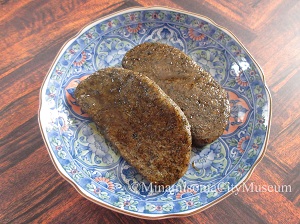 皿の上に焼いて砂糖醤油をつけた凍み餅が二つのっている