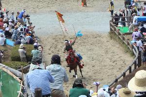 青い神旗を獲得した騎馬武者が左手に持った旗を掲げながら本陣山を駆け上る様子