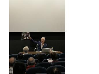 写真パネルを手に持ちながら解説する講師