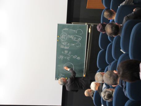 解説のために黒板に板書する講師