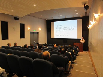 スクリーンの前で解説する講師