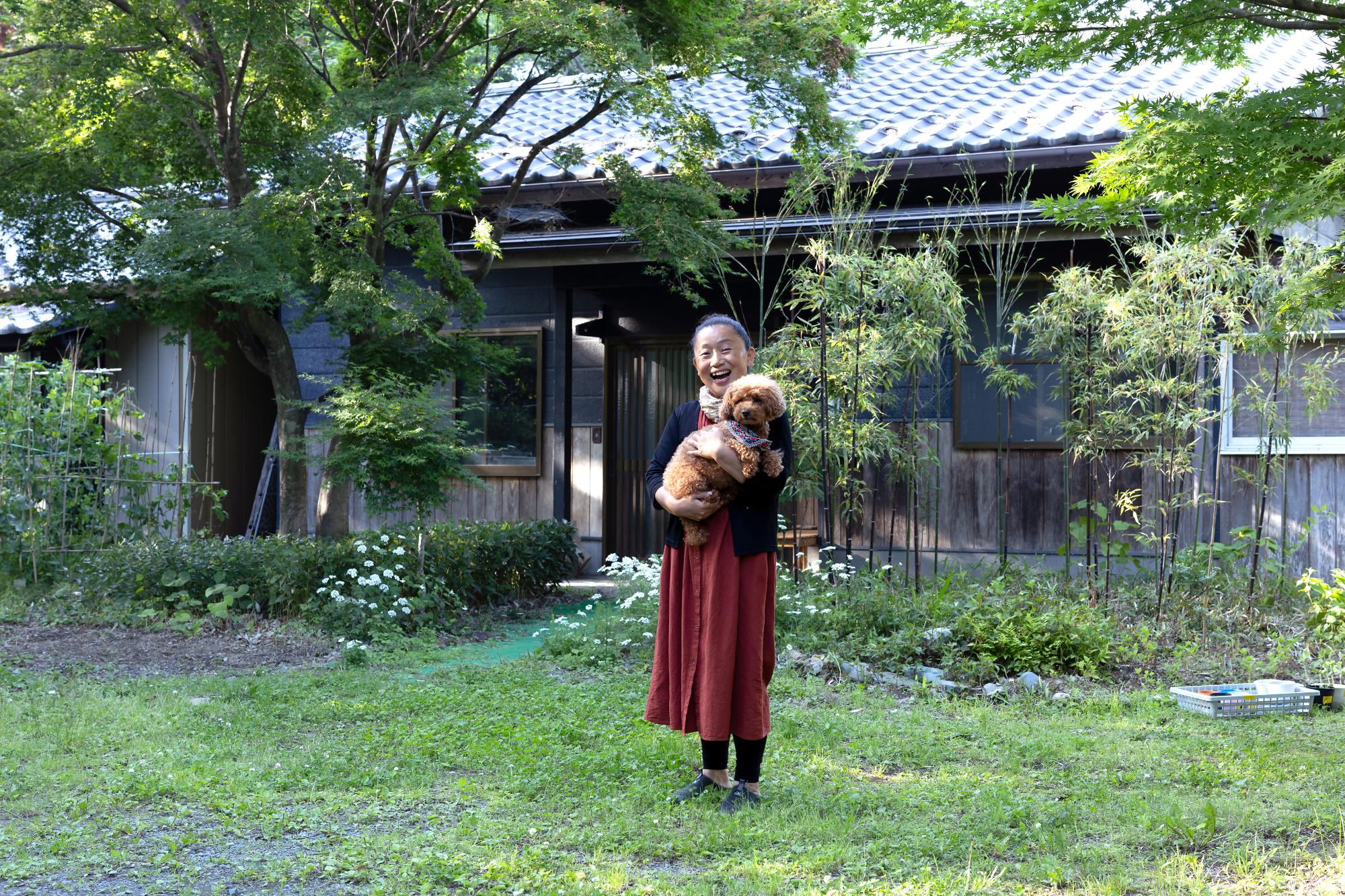 犬を抱える満面の笑みの小原さん